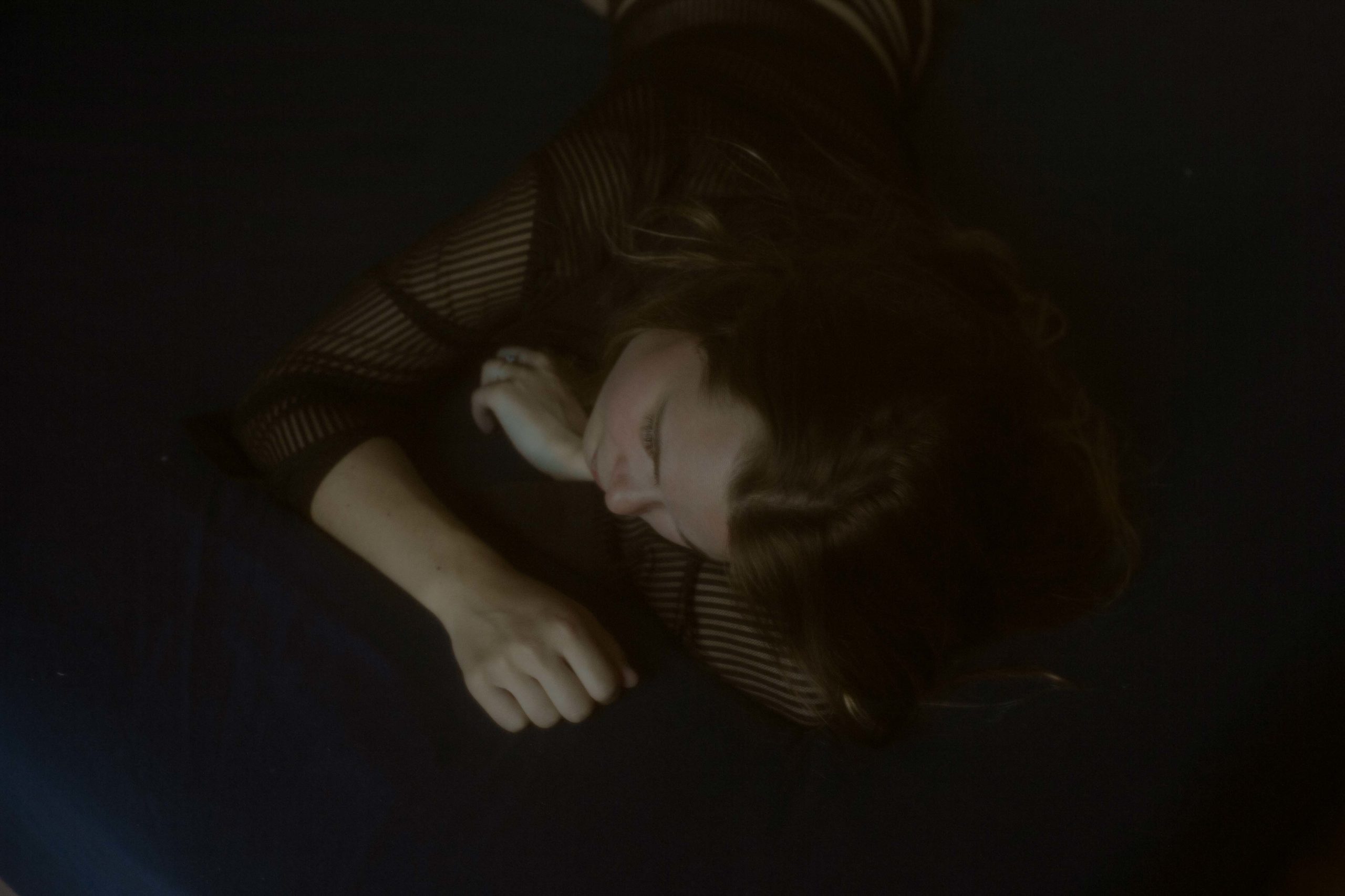 Photographie portrait intimiste allongé, la tête posée sur les bras à Bordeaux